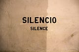 A wall with writing that says Silencio and Silence