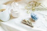 clear and blue crystals on a white background with a candle