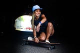 A girl around the age of 18 sitting on skateboard
