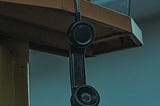 This is an image of a telephone hanging by wire, showcasing the call that I missed. — alt text for medium boost.