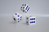 Three dice in various stages of rolling.