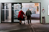 2 elderlys walking inside the hospital.