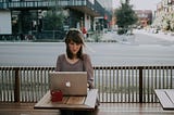 woman sitting outside looking at her laptop