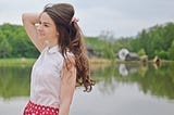 Woman holding long hair. How I Finally Got My Hair To Grow Insanely Long While Maintaining Its Health