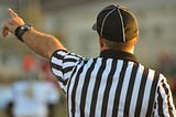 A referee for sports pointing or signaling the play.