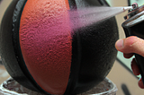 A basketball being spray painted from 10 inches away