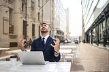 A frustrated man sitting with a laptop trying to solve a problem