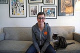 An image of Debra Cleaver sitting on a couch next to a cat.