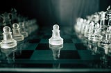 A pawn piece stands at the center of a chess board