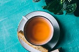 Image of a cup of tea next to a book