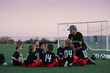 Image of a soccer coach talking to his players.