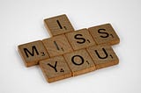 “I miss you” spelled out in Scrabble tiles