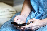 photo of person in hospital gown looking at their phone