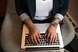 View from above of a person typing on a laptop.