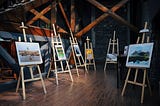six paintings displayed on easels