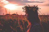 Lone girl wearing a flower crown in a field of flowers