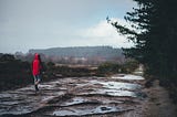 Child walking along a muddy path in the rain