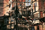 Snapshot of hundreds of wires coming from all directions to be anchored to a power pole.