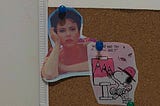 A small corkboard with a pinned cutout of Scarlett Johansson as Midge Campbell in Asteroid City (2023) and Snoopy.