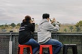 Two people using smartphones. One person is using it in portrait position and another in landscape position.