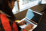 Woman working on code on a laptop
