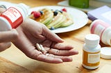 Woman pouring supplements into palm