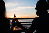 silhouette of a man and a woman celebrating on the beech for article by Larry G. Maguire