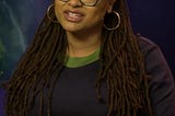 A picture of Ava DuVernay with her black glasses on.