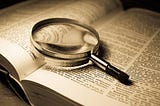 A magnifying glass over an open dictionary