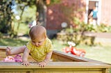 Baby Climbing out of Sandbox