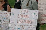 Protestors hold signs protesting gun violence in schools