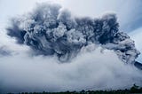 Large gray cloud of ash and smoke rising from volcanic eruption