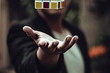 A Rubik’s cube floating above a man’s open palm