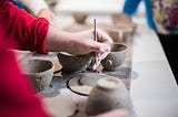 person etching pottery