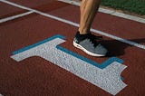 Person’s foot lifted to run on a track above the number 1