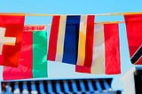 A series of flags hang together above a blue roof, a display of international solidarity