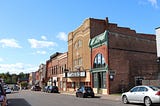 Old brick buildings on a town’s main street with cars
