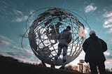 Person standing in front of a large world globe.