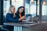 A manager and her team member discussing a report together.