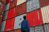 A man looking at big tall wall of containers