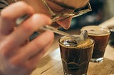 A man smelling a cup of coffee