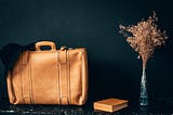 An antique leather travel bag and a book await their next adventure
