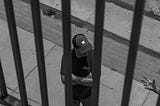 Man standing behind what look like bars