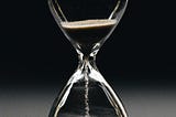 An hourglass with sand running through.