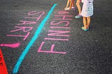 Children chalking a finish line on the ground