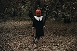 Picture of a person wearing a pumpkin head.