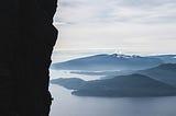 man looking at beautiful landscape from edge of cliff