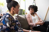 Two women talking and exchanging ideas, looking familiar and warm with each other