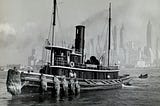 A black-and-white image of an old steamship, with a skyscraper-lined waterfront in the background