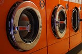 Three washing machines in a laundry
